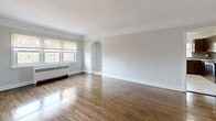Located at 130 St Paul Ave in Brantford, Ontario, this 2-bedroom, 1-bathroom unit offers a functional and well-appointed single-floor layout. The combined living and dining area is a welcoming, open space featuring gleaming hardwood floors, soft neutral tones, and natural light streaming through a large window. A charming arched doorway adds a classic architectural touch, connecting the living space to the hallway beyond.

The kitchen is thoughtfully designed with rich dark-brown cabinetry, light stone-look countertops, a decorative mosaic tile backsplash, and light ceramic tile flooring. It is fully equipped with stainless steel appliances including a refrigerator, electric range, over-the-range microwave, and dishwasher.

Both bedrooms continue the hardwood flooring theme and are finished in calming neutral tones with ample natural light from individual windows. The primary bedroom includes a ceiling fan and closet access. A connecting hallway with hardwood floors leads to the two closets, providing practical storage solutions.

The bathroom is clean and bright, featuring a full tub and shower combination with white tile surround, gold-tone fixtures, and a window for natural ventilation. Radiator heating is present throughout the unit, ensuring consistent warmth. This unit offers a comfortable, move-in-ready layout in a well-established Brantford neighbourhood.