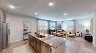 Located in Spring, TX, this single-story 2-bedroom, 2-bathroom home offers a thoughtfully designed open-concept layout that seamlessly connects the kitchen, dining, and living areas. The kitchen is a standout feature, showcasing rich dark-toned cabinetry, stainless steel appliances, a subway tile backsplash, and a generous granite-topped island with bar seating — ideal for both cooking and entertaining. Light wood-style flooring flows throughout, complementing the neutral color palette and recessed lighting overhead. Large windows dressed with blinds and sheer curtains invite abundant natural light into every room. The spacious primary bedroom includes a ceiling fan, walk-in closet with wire shelving, and an en-suite bathroom featuring a tub/shower combo with classic white subway tile surround and granite vanity. The second bedroom offers flexibility as a home office or guest room, with dual windows and ample space. A dedicated laundry area accommodates a full-size washer and dryer with overhead wire shelving for storage. Two well-appointed closets provide practical organization throughout the home. Clean lines, consistent finishes, and a bright, open atmosphere define this comfortable and functional living space.