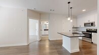 Located at 1500 Bell Road in Nashville, TN, this well-appointed one-bedroom, one-bathroom unit offers a thoughtfully designed open-concept layout across a single floor. The kitchen serves as a central highlight, featuring crisp white shaker cabinets with matte black hardware, dark countertops, a kitchen island with pendant lighting, and a full suite of stainless steel appliances including a range, microwave, and refrigerator. The kitchen flows seamlessly into the living area, which is finished with warm wood-look flooring that extends throughout the main living spaces. The living room is bright and airy, with a ceiling fan, a large window, and a glass-panel door that invites natural light. The spacious primary bedroom is carpeted for comfort and includes a ceiling fan and a generous window with outdoor views. The bathroom is elegantly finished with large-format tile flooring, white cabinetry with dark countertops and matte black hardware, and a glass-door shower enclosure. A dedicated closet provides additional storage. The clean, neutral color palette and modern finishes throughout create a cohesive and contemporary ambiance.
