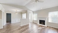 Located at 5927–5929 Highdale Cir in Alexandria, VA, this single-floor residence offers a thoughtfully designed layout across a comfortable footprint. The open living room is a standout space, featuring soaring vaulted ceilings, a ceiling fan, a classic fireplace with a white mantle surround, and wide-plank wood-style flooring that extends throughout the main areas. Wainscoting panels and multiple windows with blinds allow natural light to fill the room, creating a bright and airy atmosphere with views of surrounding greenery. The kitchen is equipped with dark shaker-style cabinetry, white countertops, and a full suite of stainless steel appliances, including a range, over-the-range microwave, and refrigerator. Two full bathrooms are finished with navy blue vanity cabinetry, white countertops, a lighted mirror, and a tiled shower-tub combination. The bedrooms feature plush carpeting and natural light from windows with blinds. A dedicated office provides flexible workspace, while an in-unit laundry room houses a full-size washer and dryer. Three closets offer ample storage throughout. The unit's neutral palette and clean finishes lend a fresh, move-in-ready feel.