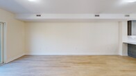 Located at 770 E Ashland St in Brockton, Massachusetts, this two-story residence offers a practical and modern layout across two evenly distributed floors. Light hardwood flooring flows consistently throughout the home, creating a cohesive and clean aesthetic in every room.

The first floor hosts the main living area, kitchen, and at least one bathroom. The kitchen is a standout feature, showcasing dark gray cabinetry, granite countertops, a central island with pendant lighting, white appliances including a gas range, dishwasher, and refrigerator, plus a window that brings in natural light. The open living room provides generous space with multiple HVAC vents and neutral walls, creating a versatile, comfortable environment. A staircase with a wood banister connects both floors.

Upstairs, three bedrooms offer well-proportioned spaces with light-filled windows and closet access. The primary bedroom provides a comfortable footprint with clean, neutral finishes. All three bathrooms maintain a consistent design language, featuring granite-topped dark wood vanities, tiled flooring, and combination tub-shower units with chrome fixtures. The overall ambiance is clean, modern, and move-in ready.