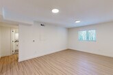 Located on Memorial Drive SE in Atlanta's vibrant Eastside corridor, this thoughtfully updated one-bedroom, one-bathroom unit delivers a clean, modern aesthetic throughout its efficiently designed single-floor layout. Light wood-look flooring runs continuously through every room, creating a cohesive and airy feel. The living room is bright and open, featuring recessed round ceiling lights, a thermostat panel, and a window that lets in natural greenery views. The kitchen stands out with crisp white shaker cabinetry, granite countertops, black hardware accents, and a full suite of stainless steel appliances including a range, over-the-range microwave, and dishwasher. Adjacent to the kitchen, a stacked washer and dryer unit is neatly integrated alongside the refrigerator, adding everyday convenience. The bedroom is generously proportioned with a ceiling fan, a large window for natural light, and two double-door closets offering ample storage. The bathroom is tastefully finished with subway tile surrounding the tub-shower combo — accented by a sage green tile stripe — paired with a granite-top vanity, matte black fixtures, and stone-look tile flooring. Clean white walls and consistent finishes throughout give the space a polished, move-in-ready character.
