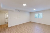 Located on Memorial Drive SE in Atlanta's vibrant Eastside corridor, this thoughtfully updated one-bedroom, one-bathroom unit delivers a clean, modern aesthetic throughout its efficiently designed single-floor layout. Light wood-look flooring runs continuously through every room, creating a cohesive and airy feel. The living room is bright and open, featuring recessed round ceiling lights, a thermostat panel, and a window that lets in natural greenery views. The kitchen stands out with crisp white shaker cabinetry, granite countertops, black hardware accents, and a full suite of stainless steel appliances including a range, over-the-range microwave, and dishwasher. Adjacent to the kitchen, a stacked washer and dryer unit is neatly integrated alongside the refrigerator, adding everyday convenience. The bedroom is generously proportioned with a ceiling fan, a large window for natural light, and two double-door closets offering ample storage. The bathroom is tastefully finished with subway tile surrounding the tub-shower combo — accented by a sage green tile stripe — paired with a granite-top vanity, matte black fixtures, and stone-look tile flooring. Clean white walls and consistent finishes throughout give the space a polished, move-in-ready character.