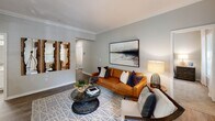 Located at 1301 Ivy Meadow Dr in Charlotte, NC, this single-floor residence offers a thoughtfully designed layout with modern finishes and a cohesive, neutral color palette throughout. The open-concept kitchen is a standout feature, outfitted with crisp white shaker cabinetry, white quartz countertops, a subway tile backsplash, and stainless steel appliances including a dishwasher, microwave, and electric range. Wood-look flooring runs through the kitchen and main living areas, adding warmth and durability. The living room is generously sized with crown molding accents and flows naturally into a bright dining area framed by large windows with elegant two-tone drapes that invite abundant natural light. Multiple bedrooms provide comfortable retreats, each featuring plush carpeting, ceiling fans, and sizable windows with garden views. The bathrooms are finished with white cabinetry, quartz countertops, wood-look tile flooring, large mirrors, and a tiled soaking tub and shower combination. The overall ambiance is clean, contemporary, and welcoming, with a consistent design language that balances practicality and style throughout every room of this Charlotte residence.