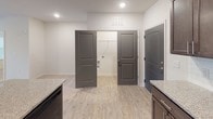 This single-floor residence offers a clean, contemporary design with consistent finishes and thoughtful details throughout. The kitchen is a standout space, featuring rich dark-brown shaker-style cabinetry, granite-look countertops, a classic white subway tile backsplash, and black appliances including a range, microwave, and refrigerator. Light wood-look flooring runs through the kitchen and connects seamlessly to the adjoining areas, enhancing the sense of continuity.

The living area is bright and welcoming, highlighted by neutral carpet, a ceiling fan with light fixture, and a set of French doors that invite natural light and provide outdoor access. The bedrooms are carpeted and generously proportioned, with large windows fitted with blinds that allow for ample natural light and privacy. Closet space is accessible directly from the bedroom areas.

The unit includes two bathrooms. The primary bathroom features a soaking tub with tiled surround and built-in shelving, offering a relaxing retreat. The secondary bathroom is outfitted with a tub-shower combination, a vanity with granite-look countertops, dark wood cabinetry, and light wood-look flooring. Both bathrooms are finished with brushed nickel hardware and well-lit mirrors. Overall, the space presents a fresh, move-in-ready environment with consistent, modern styling.