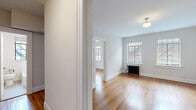 Located at 817 Hillsborough St in Raleigh, NC, this two-bedroom, one-bathroom unit blends classic architectural character with functional living. Warm hardwood floors extend throughout the entire space, lending continuity and timeless appeal to every room. The layout is efficiently organized across a single floor, connected by two hallways that provide smooth flow between spaces.

The spacious primary bedroom is a standout feature, offering generous proportions, multiple windows with natural light, and a classic cast-iron radiator that adds vintage charm. A built-in closet with a hanging rod provides practical storage. The second bedroom is a cozy, well-proportioned room with its own closet and the same rich hardwood flooring.

The galley-style kitchen is thoughtfully equipped with white cabinetry, granite countertops, stainless steel appliances including a full-size refrigerator, and open wood shelving that adds a contemporary touch. The bathroom features clean white tile surrounds, a full soaking tub, and a window that brings in natural light.

Throughout the unit, bright white walls, crisp white trim, and classic millwork details contribute to a clean, light-filled ambiance. The combination of period details like the cast-iron radiators and updated finishes in the kitchen and bath make this a well-balanced and characterful space.