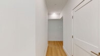 Located at 226 W Glebe Rd in Alexandria, Virginia, this modern residence offers four bedrooms and four bathrooms across a thoughtfully designed single-floor layout. Light hardwood flooring runs throughout, complementing the clean white walls and recessed lighting that give the space a bright, contemporary feel.

The open-concept kitchen is a standout feature, equipped with sleek two-tone cabinetry in white and charcoal gray, a large center island with a gas cooktop and crisp white quartz countertop, a stainless steel range hood, double wall ovens, and a full-size refrigerator. Large windows flood the kitchen and living area with natural light and offer views of surrounding greenery.

The bedrooms are generously proportioned, each featuring expansive windows — including floor-to-ceiling corner window configurations — that bring in abundant natural light and outdoor views. The spacious primary bedroom includes direct access to a private balcony overlooking the streetscape. 

The four bathrooms are finished with large-format neutral tiles, floating wood vanities with white countertops, wall-mounted toilets, and glass-enclosed showers and soaking tubs, reflecting a consistent modern aesthetic throughout. The overall ambiance is clean, minimalist, and light-filled, ideal for contemporary urban living.