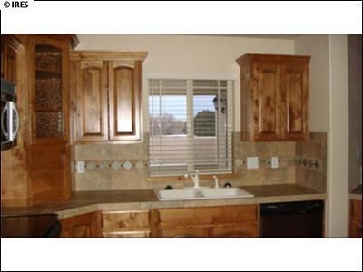 Beautiful kitchen with stainless steel appliances, knotty alder cabinets, and walk-in pantry. - 649 Triton Ave