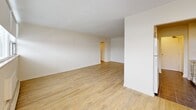 Located at 6320 Valley Way in Niagara Falls, Ontario, this two-bedroom, one-bathroom unit offers a well-organized single-floor layout with a clean, bright aesthetic throughout. Light wood laminate flooring runs through the main living areas and bedrooms, complementing the white walls and creating a warm, neutral atmosphere.

The galley-style kitchen is efficiently designed with white cabinetry, brushed nickel hardware, grey laminate countertops, tile flooring, and a window that draws in natural light. It is equipped with an electric range, microwave, and ample upper and lower cabinet storage. A hallway connects the kitchen to the rest of the unit, leading to a spacious living room that opens to a private balcony via sliding glass doors, offering views of the surrounding neighbourhood and greenery.

The primary bedroom is generously proportioned, featuring a large window, baseboard heating, and smooth white walls. The second bedroom is similarly bright, with its own window and baseboard heating unit. Both rooms offer a quiet, functional space.

The bathroom is finished with white subway tile surrounding a full bathtub and shower combination, dark floor tiles, and a small window for ventilation. The entrance and hallway provide a practical transition into the main living spaces, completing this well-laid-out unit.