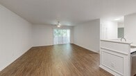 Located at 326 Commonwealth Court in Charlottesville, Virginia, this single-floor unit offers a clean, well-maintained layout with a cohesive design throughout. The living area is generously proportioned, featuring wood-style hard flooring, a ceiling fan with light fixture, and a sliding glass door that fills the space with natural light while providing direct outdoor access. Decorative wainscoting accents one wall, adding a subtle architectural detail to the otherwise neutral palette.

The kitchen is outfitted with stainless steel appliances, including an electric range, over-the-range microwave, and refrigerator. White cabinetry and light quartz-style countertops lend a crisp, contemporary feel to the space.

The bathrooms mirror this clean aesthetic, each featuring wood-style flooring, white vanities with light countertops, chrome hardware, and a mirrored medicine cabinet for additional storage.

The bedrooms are carpeted for comfort and feature neutral walls with ample natural light from standard windows. One bedroom includes a reach-in closet with a full-panel door and integrated rod for hanging storage. The overall ambiance throughout the unit is bright and neutral, offering a versatile and move-in ready living environment.