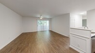 Located at 326 Commonwealth Court in Charlottesville, Virginia, this single-floor unit offers a clean, well-maintained layout with a cohesive design throughout. The living area is generously proportioned, featuring wood-style hard flooring, a ceiling fan with light fixture, and a sliding glass door that fills the space with natural light while providing direct outdoor access. Decorative wainscoting accents one wall, adding a subtle architectural detail to the otherwise neutral palette.

The kitchen is outfitted with stainless steel appliances, including an electric range, over-the-range microwave, and refrigerator. White cabinetry and light quartz-style countertops lend a crisp, contemporary feel to the space.

The bathrooms mirror this clean aesthetic, each featuring wood-style flooring, white vanities with light countertops, chrome hardware, and a mirrored medicine cabinet for additional storage.

The bedrooms are carpeted for comfort and feature neutral walls with ample natural light from standard windows. One bedroom includes a reach-in closet with a full-panel door and integrated rod for hanging storage. The overall ambiance throughout the unit is bright and neutral, offering a versatile and move-in ready living environment.