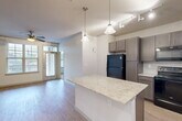 This single-story, 3-bedroom, 2-bathroom home in Houston's 77009 zip code offers a thoughtfully designed open-concept layout. The combined kitchen, dining, and living area serves as the heart of the home, showcasing light wood-style flooring, crown molding, and a ceiling fan. The kitchen is well-appointed with gray shaker-style cabinetry, light granite countertops, a subway tile backsplash, a central island with pendant lighting, track lighting, and black stainless appliances including a refrigerator, range, microwave, and dishwasher. The living area benefits from large windows and a glass door that invite natural light throughout. The three bedrooms feature plush carpeting, ceiling fans, and window blinds, while the primary bedroom includes its own walk-in closet with built-in shelving and rods. The primary bathroom offers a granite-topped vanity with gray cabinetry and a walk-in shower. A second walk-in closet adds additional storage elsewhere in the home. A dedicated laundry area and a connecting hallway complete the functional floor plan, making this a well-organized and comfortable residence.