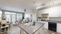 Located at 801 NW 10th St in Oklahoma City, this two-bedroom, two-bathroom residence offers a thoughtfully designed single-floor layout with contemporary finishes throughout. The open-concept kitchen is a standout feature, boasting crisp white cabinetry, dark countertops, black appliances, track lighting, and a central island with bar seating — ideal for both cooking and casual dining. Polished concrete floors run through the main living areas, adding an industrial-modern character to the space.

The living room is bright and inviting, anchored by French doors that open to a private balcony and allow generous natural light to fill the room. Both bedrooms are comfortably sized, with large windows offering outdoor views, neutral carpet flooring, and access to dedicated closets with built-in shelving. The primary bedroom connects to its own bathroom, which features a dark-topped vanity with white cabinetry and polished concrete floors.

The second bathroom is finished with large-format stone-look tile in the tub/shower surround, complementing the warm, neutral palette found throughout the residence. Each room reflects a clean, modern aesthetic, creating a cohesive and comfortable living environment well-suited for everyday life in Oklahoma City.