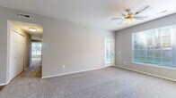 Located at 2645 River Oaks Dr in Columbus, Ohio, this single-story, 3-bedroom, 2-bathroom home offers a practical and comfortable layout. The open-concept living room and kitchen area form the heart of the home, with plush carpeting, neutral gray walls, and ceiling fans providing a bright and airy atmosphere. Large windows allow generous natural light to fill the living space, with a sliding glass door leading out to a private patio. The kitchen is well-appointed with rich dark wood cabinetry, stainless steel appliances including an electric range and dishwasher, wood-look flooring, and a tile backsplash. A dedicated pantry adds additional storage convenience. The three bedrooms feature soft carpeting and neutral tones, with the primary bedroom offering a comfortable, well-sized retreat. Both bathrooms are functional, with one featuring a full tub-shower combination with white tile surround and wood-look flooring. A carpeted hallway connects the bedrooms, while seven closets throughout provide exceptional storage. The home also includes an attached garage with built-in overhead shelving, a dedicated laundry area, and a utility room, rounding out a well-organized and highly functional living space.