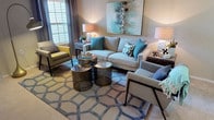 This 1-bedroom, 1-bathroom single-story residence is designed to maximize both function and style across a well-organized floor plan. The living area serves as the heart of the home, featuring warm neutral walls, natural light from large windows with elegant drapery, and plush carpeting. The space comfortably accommodates a full seating arrangement, anchored by a geometric-patterned area rug and complemented by contemporary accent tables.

The galley-style kitchen is equipped with stainless steel appliances, including a gas range and refrigerator, rich wood cabinetry, granite-style countertops, a double basin sink, and light hardwood-style flooring. An in-unit washer/dryer hookup is also conveniently located within the kitchen corridor.

The bedroom offers a serene retreat with soft carpeting, multiple windows allowing natural light, and ample space for a full furniture arrangement. A dresser area with mirrored wall décor adds depth to the room, with a hallway leading directly to the bathroom.

The bathroom features a granite-topped vanity with a wood cabinet base, a large mirror, and a full shower-tub combination. Neutral tones throughout create a clean, cohesive aesthetic that ties the entire residence together.