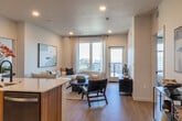 Located at 2333 Calle Del Mundo in Santa Clara, CA, this thoughtfully designed residence offers four bedrooms and two bathrooms across a single-floor layout. The open-concept living and kitchen area serves as the heart of the home, featuring wide-plank light wood flooring, recessed lighting, and large windows that flood the space with natural light and frame elevated city views. A private balcony extends the living area outdoors.

The kitchen is a standout feature, showcasing warm wood cabinetry, a stone-topped island with an undermount sink and bar seating, a tile backsplash, and a full suite of stainless steel appliances including a gas range and french door refrigerator. The layout flows seamlessly into the living room, which benefits from abundant natural light and an airy, modern ambiance.

Both bathrooms are finished with wood-tone vanities, white quartz countertops, large mirrors, matte black fixtures, and tub-shower combinations with built-in shelving. Clean white paneled doors with matte black hardware are consistent throughout, contributing to the home's cohesive contemporary aesthetic. The four bedrooms are well-proportioned, with the primary bedroom offering a generous footprint and access to natural light. A dedicated closet and hallways with light wood flooring complete this well-appointed residence.