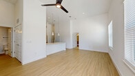 Located in Boerne, TX, this well-appointed single-story residence offers 2 bedrooms and 2 bathrooms within a thoughtfully designed open floor plan. The living area immediately impresses with soaring ceilings and light-toned wood-look flooring that flows seamlessly throughout the main spaces. A ceiling fan anchors the room, adding both function and style to the bright, airy environment.

The kitchen is a standout feature, boasting a large island with elegant quartz countertops, an integrated sink with a modern faucet, and grey cabinetry complemented by stainless steel appliances. Stylish pendant lights with gold interiors hang above the island, adding a warm, contemporary accent. A pantry and dedicated laundry area provide practical storage and utility solutions.

The bedrooms are carpeted for comfort and feature impressively tall ceilings with ceiling fans. The primary bedroom includes a walk-in closet, while multiple additional closets throughout the home ensure ample storage. One bedroom is bathed in natural light through dual windows overlooking greenery. The bathrooms are clean and modern, with one featuring a tub-shower combo, wood-look tile flooring, and a wide vanity mirror. A patio rounds out this well-equipped home.
