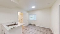 Located at 313 E St Joseph St in Lansing, Michigan, this efficiently designed one-bedroom, one-bathroom unit offers a well-organized single-floor layout that maximizes every square foot. Light-toned luxury vinyl plank flooring runs throughout the entire space, providing a clean, cohesive look and easy maintenance.

The kitchen is a standout feature, equipped with white cabinetry, under-cabinet lighting, a full-size refrigerator, and a range. A peninsula with a striking marble-pattern countertop and an integrated sink serves as both a functional workspace and a natural divider between the kitchen and living areas, adding a touch of modern style.

The bedroom offers a comfortable and private retreat, complete with a closet featuring a paneled white door. A window with blinds invites natural light and offers a view of surrounding greenery. A baseboard heating unit ensures year-round comfort.

The bathroom is thoughtfully appointed with light wood-tone LVP flooring, a white vanity with under-sink storage, a lighted mirror above, and a grab bar for added accessibility. The overall palette throughout the unit is bright and neutral, with cream-toned walls that contribute to an open, airy ambiance ideal for comfortable everyday living.