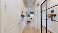 Located at 1320 Old Glendenning Rd in Celina, TX, this single-story 2-bedroom, 3-bathroom home offers a thoughtfully designed layout that maximizes every square foot. Light wood-tone flooring flows throughout, complementing the crisp white walls and recessed lighting that create a clean, modern aesthetic.

The entryway hallway provides a welcoming introduction, leading directly into a comfortable living area featuring a ceiling fan, large windows with natural light, and stylish finishes. The kitchen is a standout, boasting white shaker cabinetry, white quartz countertops, stainless steel appliances including a refrigerator, range, microwave, and dishwasher, and a kitchen island ideal for casual dining.

The primary bedroom is a well-proportioned retreat with a ceiling fan, neutral walls, and direct access to a private en-suite bathroom. The primary bath features a white vanity with quartz countertops, a glass-enclosed walk-in shower with tile surround, and a dedicated walk-in closet with generous hanging space. The second bedroom is equally inviting, with a ceiling fan and ample natural light.

Three full bathrooms serve the home, each finished with white cabinetry and clean tile work. Two hallways and two closets contribute to the home's practical storage and circulation. The overall ambiance is modern, bright, and efficiently organized.