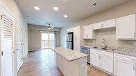 Located at 1735 E Valley Water Mill Rd in Springfield, MO, this one-bedroom, one-bathroom unit is thoughtfully designed to maximize functionality within a compact, single-floor layout. The open-concept kitchen and living area serves as the heart of the space, featuring warm wood-look flooring, recessed lighting, and a ceiling fan that enhances airflow throughout. The kitchen is well-appointed with crisp white shaker cabinetry, granite-style countertops, a center island with additional prep space, and a full suite of stainless steel appliances including a refrigerator, dishwasher, range, and microwave. A sliding glass door in the living area opens to a private balcony, bringing in natural light and outdoor views. The bedroom offers plush carpeting, a ceiling fan, and convenient access to both a walk-in closet and the adjacent bathroom. The bathroom continues the home's clean aesthetic with a white vanity and granite countertop. Additional practical spaces include a dedicated laundry area and utility room, rounding out this efficiently planned home with all the essentials for comfortable everyday living.