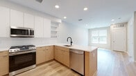 Located at 204 Wagaraw Rd in Hawthorne, NJ, this single-floor residence showcases a contemporary design aesthetic defined by clean lines, neutral tones, and quality modern finishes throughout. Light hardwood flooring runs consistently across the main living areas, creating a seamless, cohesive feel that enhances the sense of openness.

The kitchen is a standout feature, designed with a peninsula layout that connects naturally to the living area. Two-tone cabinetry pairs warm wood lower cabinets with crisp white upper cabinets and open floating shelves, complemented by white quartz countertops and a subtle tile backsplash. A matte black pull-down faucet adds a refined contrast, while stainless steel appliances — including a gas range, dishwasher, refrigerator, and built-in microwave — provide full functionality. Recessed lighting illuminates the space efficiently.

The bedroom is bright and well-proportioned, benefiting from a large window that invites natural light and frames an outdoor view. The room's warm beige walls and hardwood floors contribute to a calm, restful ambiance.

The bathroom is finished with large-format tile flooring, a wood-grain vanity with a dual sink and wide mirror, and a full soaking tub with a showerhead combo framed by clean white tile surround. In-unit laundry is also included, adding convenience to this thoughtfully designed space.