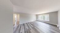Located at 1556 Village Ln in Ypsilanti, MI, this 2-bedroom, 1-bathroom residence offers a well-organized single-floor layout that makes efficient use of its space. Consistent light gray luxury vinyl plank flooring runs throughout, providing a clean, cohesive look across every room.

The living room is a comfortable and open area featuring a large window with vertical blinds that allows natural light to pour in, complemented by baseboard heating along the walls. The kitchen is fully equipped with white cabinetry, white appliances including a range and refrigerator, a single-basin sink, and ample counter space — all unified by the same LVP flooring.

The primary bedroom is a well-proportioned room featuring multiple windows with vertical blinds, a wall-mounted AC unit, and baseboard heating. The second bedroom offers closet storage, a closet with bi-fold panel doors, and its own access to natural light. Both bedrooms feature neutral-toned walls that contribute to a calm and versatile atmosphere.

The bathroom includes a vanity with white cabinetry and a countertop sink, a lighted mirror, a toilet, and a tub-shower combination, with a window providing natural ventilation. A connecting hallway links the rooms efficiently. The overall aesthetic is clean, neutral, and move-in ready.