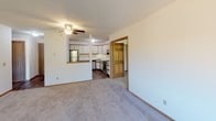 Located at 2300 Ridge Dr in St. Louis Park, MN, this single-floor unit offers a well-organized layout designed for comfortable everyday living. The spacious living room is finished with plush carpeting, a ceiling fan, and baseboard heating. Multiple windows allow natural light to fill the room, while a sliding glass door opens to a private balcony overlooking lush, mature trees, bringing a pleasant sense of nature indoors.

The kitchen is positioned adjacent to the living area in an open-concept arrangement, separated by a half-wall that maintains visual connectivity. It features wood-trimmed white cabinetry with ample storage, hardwood-style flooring, a stainless steel refrigerator and dishwasher, a black electric range, and an overhead ventilation hood.

The bedroom areas are carpeted and well-sized, each benefiting from natural light through framed windows. One bedroom includes a walk-in closet outfitted with wire shelving for organized storage. A wall-mounted air conditioning unit and baseboard heating provide year-round climate control.

The bathroom is clean and functional, featuring a large vanity with a round sink, a wide wall mirror, and warm-toned trim that echoes the wood accents found throughout the unit. Overall, the space presents a cohesive, neutral aesthetic with practical finishes.