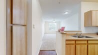 Located at 600 Park Grove Dr in Katy, Texas, this one-bedroom, one-bathroom residence offers a practical and well-organized single-floor layout. The kitchen is designed for efficiency, featuring light wood cabinetry, laminate countertops, a double-basin sink, a dishwasher, and a full suite of white appliances including a refrigerator and microwave. A pass-through counter connects the kitchen to the main living area, creating an open feel between the two spaces. The living area is finished with plush wall-to-wall carpeting and is illuminated by a ceiling fan overhead, contributing to a comfortable atmosphere. The bedroom is a well-proportioned retreat, carpeted and bright, with a large window that invites natural light and outdoor views. A ceiling fan adds comfort, and the room provides direct access to a dedicated closet for ample storage. The bathroom is clean and functional, featuring a full tub-shower combination with white tile surround, complemented by hardwood-style flooring. Additional hardwood-style flooring appears in the kitchen and bathroom areas, adding a warm contrast to the carpeted rooms. The unit also includes a private balcony, offering a personal outdoor space. Ceiling fans are present throughout, enhancing ventilation and comfort across the home.