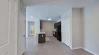 This single-story, 3-bedroom, 2-bathroom home offers a thoughtfully designed open-concept layout that maximizes functionality across its well-proportioned floor plan. Light wood-style flooring flows consistently throughout the main living areas, contributing to a clean and cohesive aesthetic.

The kitchen is equipped with dark espresso cabinetry, black appliances including a full-size refrigerator, range, and over-the-range microwave, and features a peninsula with a granite-style countertop and an undermount sink — ideal for both meal prep and casual dining. The kitchen opens directly into the living area, which is anchored by a ceiling fan and French doors that invite natural light and provide outdoor access.

Each of the three bedrooms is carpeted with light hardwood-style flooring, fitted with ceiling fans, and features windows dressed with horizontal blinds that allow for natural light and privacy. The spacious primary bedroom offers a comfortable retreat with ample room for furnishings.

The two bathrooms are finished with large-format tile flooring and dark vanity cabinetry topped with granite-style counters. The primary bath includes a walk-in shower, while the secondary bath features a shower-tub combination. Both bathrooms are bright and well-appointed. A connecting hallway ties all rooms together for a practical and efficient flow throughout the home.