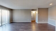 This efficiently designed 1-bedroom, 1-bathroom unit offers a thoughtful layout across a single floor, making the most of its compact footprint. The open-plan kitchen and living area serves as the heart of the space, featuring dark hardwood-style flooring that runs throughout and neutral gray walls that lend a clean, contemporary feel. The living area is generously proportioned, bathed in natural light through a sliding glass door fitted with vertical blinds that opens to the outdoors. The kitchen is equipped with granite-patterned countertops, gray cabinetry, a full-size refrigerator, an electric range, and a dishwasher — providing all the essentials for day-to-day living. The bedroom is a comfortable, well-lit room with its own ceiling fan, a window with blinds for natural light control, and direct access to both the bathroom and a dedicated closet. The bathroom features a granite-top vanity with gray cabinetry, an illuminated mirror, and clean, functional finishes. Ceiling fans in the bedroom and consistent flooring throughout contribute to a cohesive and practical living environment, well-suited for individuals or couples seeking a streamlined, move-in-ready space.