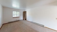 Located at 13320 Terri Lyn Ln in Holland, Michigan, this single-floor unit offers a practical and well-organized layout designed for comfortable everyday living. The interior is finished with clean white walls and warm wood-toned trim throughout, creating a bright and neutral aesthetic.

The living area features wall-to-wall carpeting and connects openly to adjacent spaces, allowing for a natural flow through the unit. Baseboard heating runs along the perimeter of the main rooms, ensuring consistent warmth. Multiple windows fitted with horizontal blinds invite natural light into the living and bedroom areas, offering views of the surrounding greenery.

The unit includes multiple carpeted bedrooms, each with windows, baseboard heating, and ample wall space. The kitchen is outfitted with solid oak cabinetry — both upper and lower — alongside a stainless steel double sink, a dishwasher, a refrigerator, and a range. Light countertops and wood-look flooring complete the functional kitchen space.

The bathroom features a full tub-shower combination, a toilet, a single vanity with storage beneath, and wood-look flooring, all finished in neutral tones for a clean, understated look. The overall layout, as visible in the dollhouse view, is compact yet efficiently arranged, making good use of the available footprint across its single level.