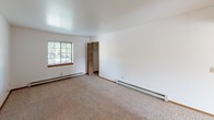 Located at 13320 Terri Lyn Ln in Holland, Michigan, this single-floor unit offers a practical and well-organized layout designed for comfortable everyday living. The interior is finished with clean white walls and warm wood-toned trim throughout, creating a bright and neutral aesthetic.

The living area features wall-to-wall carpeting and connects openly to adjacent spaces, allowing for a natural flow through the unit. Baseboard heating runs along the perimeter of the main rooms, ensuring consistent warmth. Multiple windows fitted with horizontal blinds invite natural light into the living and bedroom areas, offering views of the surrounding greenery.

The unit includes multiple carpeted bedrooms, each with windows, baseboard heating, and ample wall space. The kitchen is outfitted with solid oak cabinetry — both upper and lower — alongside a stainless steel double sink, a dishwasher, a refrigerator, and a range. Light countertops and wood-look flooring complete the functional kitchen space.

The bathroom features a full tub-shower combination, a toilet, a single vanity with storage beneath, and wood-look flooring, all finished in neutral tones for a clean, understated look. The overall layout, as visible in the dollhouse view, is compact yet efficiently arranged, making good use of the available footprint across its single level.