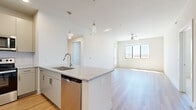 This well-designed 2-bedroom, 2-bathroom single-floor residence offers a thoughtfully laid-out floor plan that maximizes everyday functionality. The open-concept kitchen and living area serves as the heart of the space, where warm wood-style flooring flows throughout. The kitchen is outfitted with stainless steel appliances, including a French door refrigerator, electric range, built-in microwave, and dishwasher. Granite countertops and taupe cabinetry with brushed nickel hardware lend a clean, contemporary aesthetic. A peninsula with pendant lighting and a built-in sink creates a natural divide between the kitchen and living area, which is brightened by a large window and a ceiling fan.

Both bedrooms feature large windows that allow generous natural light and outdoor views. The primary bedroom connects to a private en-suite bathroom and walk-in closet, while the second bedroom offers carpeted flooring and its own closet with built-in shelving. Each bathroom is finished with granite countertops, undermount sinks, and wood-style flooring. A hallway links the private sleeping areas to the main living space, contributing to a logical and efficient layout throughout.