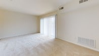 Located at 146 Chestnut Crossing Rd in Newark, Delaware, this single-floor residence offers a straightforward and practical layout designed for comfortable everyday living. The open living area is finished with light-toned wall-to-wall carpeting and neutral cream walls, creating a bright and welcoming atmosphere. A large sliding glass door floods the main living space with abundant natural light while providing access to the outdoors. The kitchen is equipped with warm oak cabinetry extending to the upper walls for generous storage, light speckled countertops, a gas range, built-in microwave, and a stainless steel sink, offering a fully functional cooking environment. The bedrooms continue the home's consistent use of plush carpeting and neutral tones, with windows that invite natural light. One bedroom features a closet with paneled doors, adding practical storage. The bathrooms are clean and well-maintained: one features a wide vanity with warm wood cabinetry, a large mirror, and a multi-bulb vanity light fixture, while the second includes a full tub-shower combination with tiled surround and tile flooring. Throughout, the residence maintains a clean, move-in ready aesthetic with a calm and functional ambiance suited to a variety of lifestyles.