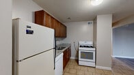 Located at 2010 E Page St in Springfield, MO, this single-floor, 2-bedroom, 1-bathroom unit offers a practical and comfortable layout across a well-utilized footprint. The space features two distinct living areas, one highlighted by large vertical-blind-covered windows that flood the room with natural light and showcase light gray laminate flooring, while the second living area features darker hardwood-style flooring and direct access to the hallway and kitchen.

The kitchen is efficiently designed with warm-toned wood cabinetry, granite-look countertops, and a full suite of white appliances including a gas range, dishwasher, and refrigerator. Light ceramic tile flooring completes the functional aesthetic, and a window provides additional natural light.

Both bedrooms are carpeted and feature ceiling fans with light fixtures, sliding closet doors with built-in shelving, and a neutral color palette. The primary bedroom is notably spacious and includes access to an additional walk-in closet area. A hallway connects the bedrooms to the shared full bathroom, which features a tiled tub-shower surround.

Three closets throughout the unit provide ample storage. Textured ceilings are consistent throughout, and neutral wall tones create a clean, move-in-ready atmosphere.
