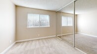 Located at 6244 Hazel Ave in Orangevale, CA, this one-bedroom, one-bathroom unit offers a well-organized, single-floor layout designed for efficient everyday living. The galley-style kitchen is a functional highlight, featuring white cabinetry that extends to the ceiling for ample storage, stainless steel appliances including a refrigerator, range, and dishwasher, light stone countertops, a stainless steel sink, and wood-look laminate flooring. A window at the end of the kitchen allows natural light to brighten the space. The open living area continues the wood-look flooring, creating a cohesive and clean aesthetic throughout the common areas. The bedroom is comfortably sized, finished with plush carpeting, warm neutral walls, a textured ceiling, and a large mirrored sliding closet that enhances the sense of space. A window with vertical blinds provides natural light and outdoor views. The bathroom is accessible directly from the bedroom and features wood-look flooring, a full-size tub and shower combo, a toilet, and a vanity with white cabinetry, a mirror, and lighted fixtures above. The unit's neutral color palette and practical layout make it an accessible and comfortable living space.