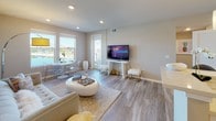 The Havana floor plan is a thoughtfully designed two-bedroom, two-bathroom residence that combines modern aesthetics with functional living on a single level. The open-concept living and dining area is anchored by light wood-style flooring, recessed lighting, and large windows and sliding glass doors that frame picturesque waterfront views, filling the space with natural light.

The kitchen is a standout feature, offering white shaker cabinetry, light quartz countertops, stainless steel appliances including a refrigerator, microwave, and range, plus a dishwasher. A central island with a double basin sink and pendant lighting provides both prep space and bar seating, seamlessly connecting to the living area.

The primary bedroom features a tray ceiling with a ceiling fan, plush carpeting, and dual windows showcasing serene water views. Its en-suite bathroom includes a double-sink vanity with white cabinetry and a separate shower. The second bedroom is equally comfortable with its own ceiling fan and access to a full bathroom featuring wood-look tile flooring and a single vanity. A stacked in-unit washer and dryer adds everyday convenience to this well-appointed residence.