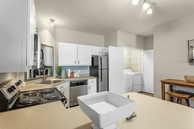 Experience the convenience and style of this contemporary kitchen and laundry area. - Fairways at Lincoln