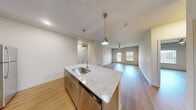Located at 2902 Pat Booker Rd in Universal City, TX, this single-story, three-bedroom, two-bathroom home offers a well-designed layout with consistent luxury vinyl plank flooring throughout. The open-concept kitchen and living area serves as the heart of the home, featuring a large granite-topped island with a stainless steel sink, pendant lighting, tile backsplash, and an abundance of taupe cabinetry. Stainless steel appliances, including a refrigerator, range, and built-in microwave, complete the modern kitchen. The living room is bright and airy, with a ceiling fan, neutral walls, and a glazed door that allows natural light to pour in. Each of the three bedrooms is generously proportioned, with ceiling fans, large windows with blinds, and clean white walls that create a calm, versatile atmosphere. The spacious primary bedroom includes direct access to an en-suite bathroom, which features a granite-topped dual vanity with gray cabinetry, a large mirror, and a soaking tub with tile surround. The second bathroom also includes a tiled tub-shower combination. A dedicated closet adds practical storage. The home's clean, modern aesthetic, neutral palette, and thoughtful layout make it a comfortable and functional living space.