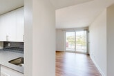 Located at 50 Park Row W in Providence, Rhode Island, this modern 2-bedroom, 3-bathroom residence offers a thoughtfully designed single-floor layout with generous living space. Light hardwood flooring flows consistently throughout, complementing the clean, contemporary aesthetic of bright white walls and trim.

The open living and dining area is a standout feature, bathed in natural light through large sliding glass doors that lead to a private balcony with sweeping views of the Providence skyline and surrounding greenery. A dedicated den provides flexible additional space ideal for a home office or study.

The galley-style kitchen is efficiently designed with white shaker cabinetry, stainless steel appliances including a refrigerator, range, and microwave, a gray tile backsplash, and sleek countertops — all illuminated by recessed and overhead lighting.

The spacious primary bedroom includes a walk-in closet with built-in shelving, offering excellent storage. Two additional closets serve the rest of the residence. All three bathrooms are finished with clean, classic fixtures including tub-shower combinations, vanities with mirrors, and hardwood flooring.

With a balcony, den, dedicated dining room, and abundant natural light throughout, this residence delivers a functional and modern living experience in the heart of Providence.