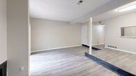 Located at 1669 Randolph Pl in Memphis, TN, this two-bedroom, two-bathroom two-story home offers a functional and comfortable layout spread across two floors. The main level features an open-concept living and dining area finished with light wood-look luxury vinyl plank flooring. A standout wood-burning fireplace anchors the living room, while a structural column subtly defines the transition between living and dining spaces. Sliding glass doors allow natural light to pour in and provide access to an outdoor area. The kitchen is well-appointed with white shaker cabinetry, granite-look countertops, stainless steel appliances including a dishwasher, and matching LVP flooring that ties seamlessly into the main living space. Upstairs, both bedrooms are carpeted for comfort and feature neutral tones, textured ceilings, and ample natural light from windows with blinds. The generously sized primary bedroom includes a ceiling fan, an en-suite bathroom with white tile surround tub/shower and granite-look vanity countertop, and direct bathroom access. The second bedroom offers a built-in closet and easy hallway access to the second full bathroom. Both bathrooms feature clean white tile work. Hallways on each floor connect the spaces efficiently, completing a well-organized floor plan.