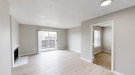 Located at 2500 Guerrero Drive in Carrollton, TX, this two-bedroom, one-bathroom single-story unit offers a thoughtfully laid-out floor plan with a mix of light wood-style flooring and plush carpet throughout. The living room is a welcoming space highlighted by a classic fireplace with a clean white surround and a sliding glass door that opens to a private balcony, filling the room with natural light and outdoor views. Adjacent to the living area, the kitchen features grey shaker-style cabinetry, light countertops, a white subway tile backsplash, and stainless steel appliances including a dishwasher, range, and microwave — all set on light tile flooring. Both bedrooms are carpeted and equipped with ceiling fans, offering a comfortable retreat. The primary bedroom is a well-proportioned space with its own closet, while the second bedroom includes a window with outdoor views. Two closets provide convenient storage throughout. The full bathroom includes a tiled tub-shower combination and light wood-style flooring, maintaining the clean, neutral aesthetic found across the rest of the unit. Neutral warm-grey walls and textured ceilings carry through each room, creating a cohesive and move-in-ready living environment.