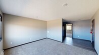 Located at 1241 Grand Ave in Marion, Iowa, this single-floor unit offers a straightforward, functional layout with a clean and neutral aesthetic throughout. The living and bedroom areas are finished with plush gray carpeting and neutral-toned walls, creating a calm and versatile environment. Textured ceilings are consistent throughout the space, and baseboard heating units are present in multiple rooms, providing efficient warmth. Several rooms are equipped with ceiling fans, adding to overall comfort. Windows allow natural light to filter in, offering views of the surrounding neighborhood.

The kitchen features dark wood cabinetry extending to the ceiling for ample storage, complemented by dark countertops and wood-look vinyl plank flooring. Full appliances are included, with a side-by-side refrigerator, electric range, and built-in microwave. The space is designed for practical everyday use with a straightforward galley-style configuration.

The bathroom includes a dark-framed vanity mirror with overhead lighting, a single-sink vanity with dark wood cabinetry, and dark vinyl plank flooring that ties in with the kitchen aesthetic. The unit's overall design is consistent and utilitarian, making it well-suited for comfortable everyday living in a residential Marion neighborhood.