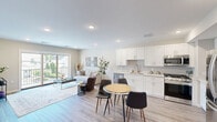 Located at 228 Morris Ave in Long Branch, NJ, this thoughtfully designed 1-bedroom, 1-bathroom residence offers a clean, modern aesthetic across a single floor. The open-concept layout seamlessly connects the kitchen, dining area, and living room, creating a bright and functional shared space bathed in natural light. The kitchen is outfitted with crisp white shaker cabinetry extending to the ceiling, a subway tile backsplash, light quartz countertops, and a full suite of stainless steel appliances including a gas range, built-in microwave, dishwasher, and French door refrigerator. Light wood-tone flooring runs throughout, lending warmth and continuity. The living room is anchored by large sliding glass doors that open to a private balcony overlooking the neighborhood, flooding the space with natural light and outdoor views. The bedroom is a well-proportioned retreat featuring a window with neighborhood views, a dedicated closet, and continued wood-tone flooring. The full bathroom features large-format tile flooring, a white vanity with storage, and a tub-shower combination. A dedicated in-unit laundry room with a full-size washer and dryer adds everyday convenience. Recessed lighting throughout completes the polished, contemporary feel of this well-appointed residence.