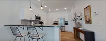 This 710 square foot single-story residence in Springfield, MO, showcases a thoughtful blend of modern design and functionality. The open-concept layout seamlessly integrates the kitchen and living areas, creating a spacious feel despite the compact footprint. The kitchen boasts sleek white cabinetry, stainless steel appliances, and ample counter space, ideal for culinary enthusiasts.

The living room is bathed in natural light from large windows and sliding glass doors, which lead to an outdoor area. A striking feature wall with wooden slats adds warmth and texture to the space. Contemporary furnishings, including a geometric coffee table and modern shelving, complement the room's aesthetic.

A dedicated office space offers a productive work environment, complete with large windows that provide plenty of natural light. The full bathroom, while not pictured, likely continues the home's modern design theme.

Throughout the home, hardwood floors lend a cohesive and warm atmosphere. The neutral color palette is punctuated by carefully chosen decor elements, creating a harmonious and inviting ambiance. Despite its modest size, this home efficiently utilizes every square foot, offering a comfortable and stylish living space.