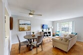 This two-story, 3-bedroom, 2-bathroom home in Alexandria, Virginia offers a thoughtfully designed layout spread evenly across two floors. The main level features a bright, open-concept living and dining area adorned with classic parquet hardwood flooring that flows seamlessly throughout. Large windows invite abundant natural light, and a ceiling fan adds comfort to the airy living space. The adjacent kitchen is well-appointed with rich cherry wood cabinetry, dark granite countertops, and a full suite of stainless steel appliances including a gas range, built-in microwave, dishwasher, and refrigerator. A stacked washer and dryer unit is conveniently located near the second full bathroom on the main level, which features white subway tile wainscoting and a tub/shower combination. Upstairs, three bedrooms provide comfortable accommodations, including a primary bedroom with vaulted ceilings, dual windows overlooking lush greenery, and warm hardwood floors. Additional bedrooms offer ceiling fans and generous closet space. With four closets total throughout the home, storage is plentiful. The staircase connecting both floors is neatly integrated into the living area layout, and French doors offer an elegant transition to an additional room, adding functional versatility to this well-maintained Alexandria residence.