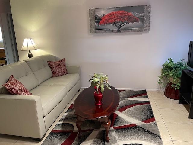 Sala de estar con TV y gran sofá de cuero. - 5921 E Boston St