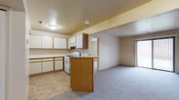 Located at 3921 Irish Hills Dr in South Bend, Indiana, this single-floor unit offers a functional and straightforward layout across its living spaces. The kitchen is well-equipped with ample white cabinetry trimmed in warm oak, generous counter space, a gas range, dishwasher, and refrigerator. Tile flooring runs throughout the kitchen area, while a peninsula with an oak-faced breakfast bar connects the kitchen to the adjoining living space, creating an open and cohesive flow between the two areas.

The living room is carpeted and spacious, featuring a textured ceiling and a sliding glass door fitted with vertical blinds that provides direct outdoor views and fills the room with natural light. A structural beam adds a subtle architectural detail to the ceiling. Bedrooms are also carpeted and bright, with one featuring a window with blinds and another offering its own sliding glass door access to the outdoors.

The bathroom includes a wide vanity with an extended countertop, oak cabinetry below, a large wall mirror, and tile flooring, offering a clean and practical design. Overall, the unit presents a neutral, move-in-ready aesthetic with consistent finishes throughout.