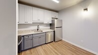 Located at 1915 Pine Bough Ln in Kannapolis, NC, this two-bedroom, one-bathroom single-story home offers a clean, modern aesthetic with thoughtfully selected finishes throughout. The open kitchen and living area serves as the heart of the home, featuring two-tone cabinetry with crisp white upper cabinets and gray lower cabinets, granite-look countertops, a stainless steel sink with a matte black faucet, and a full suite of stainless steel appliances including a refrigerator, dishwasher, microwave, and range. Light wood-style luxury vinyl plank flooring runs throughout the main living areas, adding warmth and continuity to the space. The primary bedroom is a comfortable, well-proportioned room with hardwood-style flooring, neutral walls, and a window that brings in natural light with views of the surrounding greenery. The second bedroom features plush carpeting and its own window overlooking the outdoors, creating a cozy retreat. A dedicated utility room houses a full-size washer and dryer, adding everyday convenience. The home is finished with clean white trim, six-panel interior doors with matte black hardware, and a neutral color palette throughout, giving the entire space a fresh, move-in-ready feel.