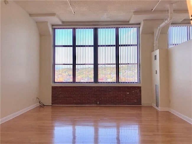 light-flooded living room with giant window - 5850 Centre Ave Apartment